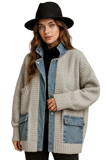 Woman wearing a beige cardigan with denim accents and a black hat on a white background